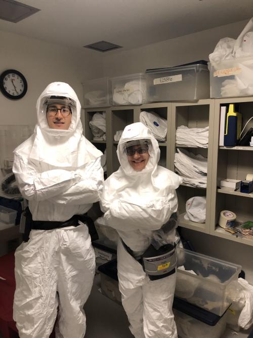 Two people in white protective body suits