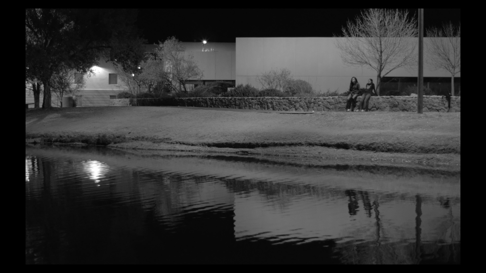 screen grab of film, two people siting in the dark