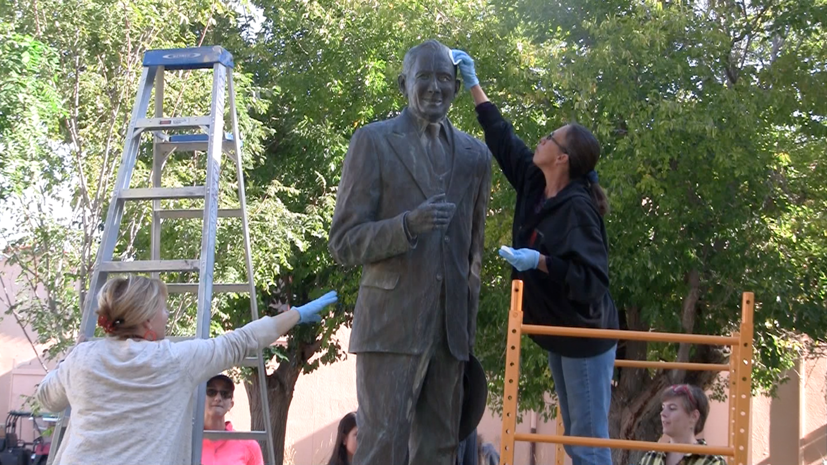 people fixing a statue